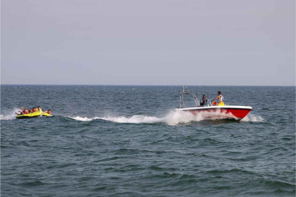 group on towable tube having fun pulled by speed boat